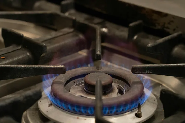 Blue flames burning on a gas hob ring
